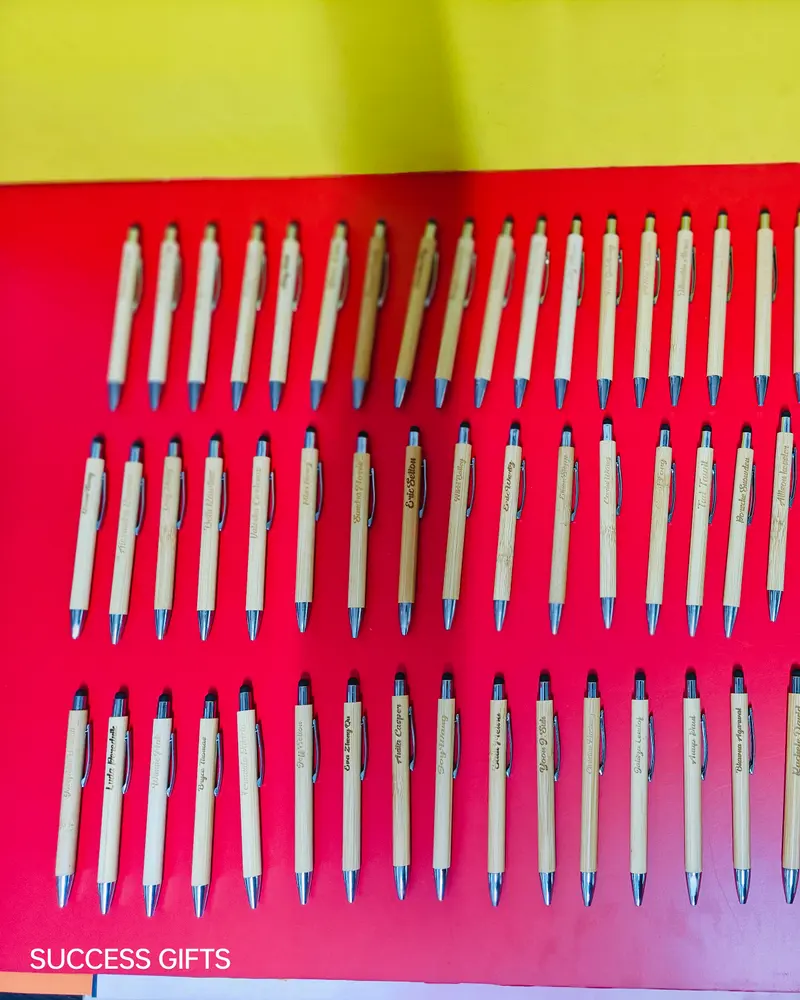 Batch of engraved bamboo pens on a red background